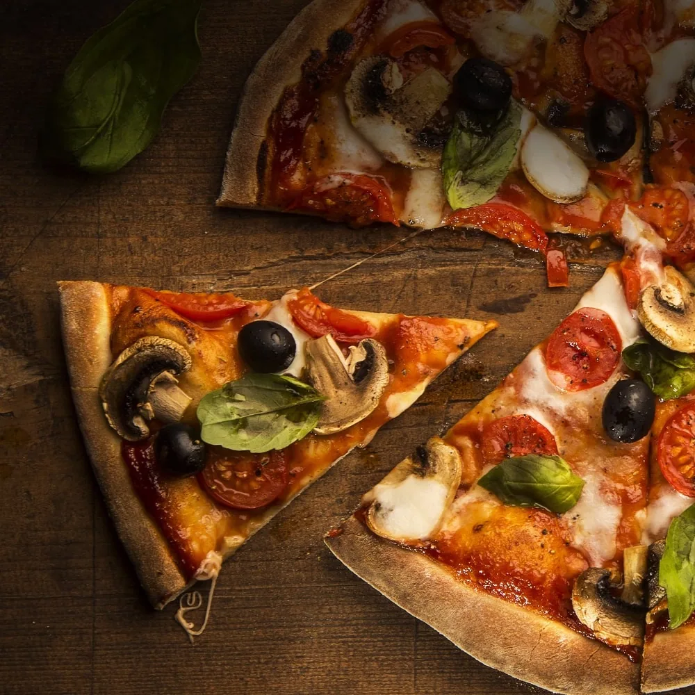Frisch gebackene Steinofen-Pizza mit knusprigem Rand, Tomatensauce, Mozzarella und Kräutern.