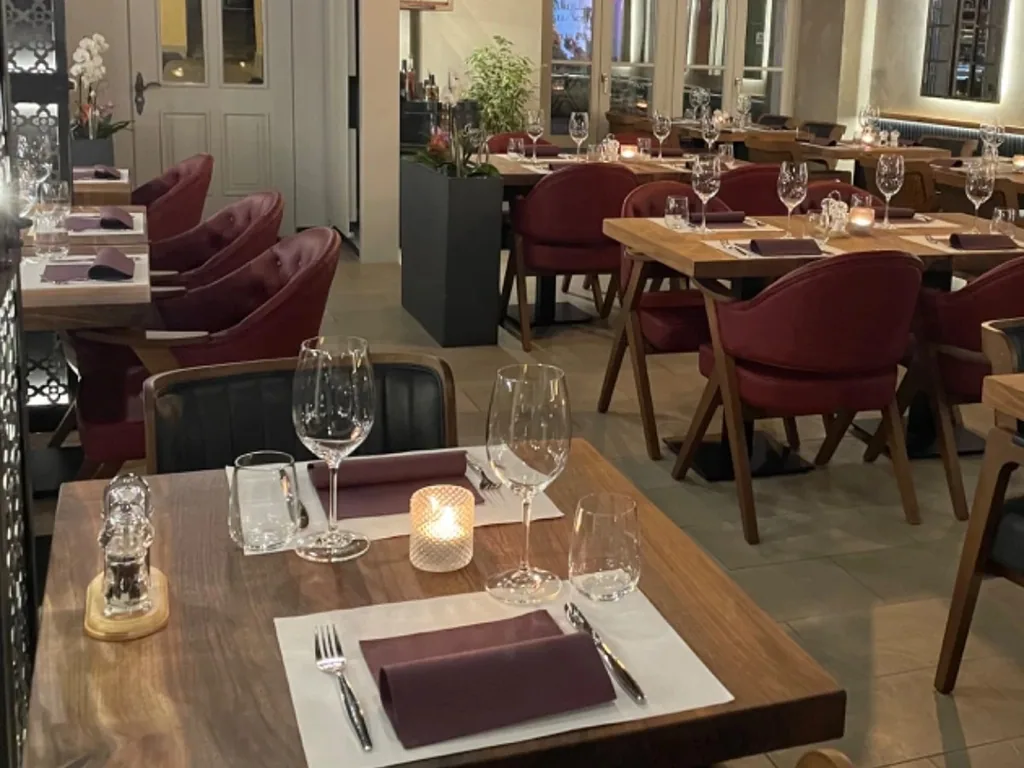 Fein gedeckter Dinnertisch mit Weingläsern, Stoffserviette und Kerzenlicht.